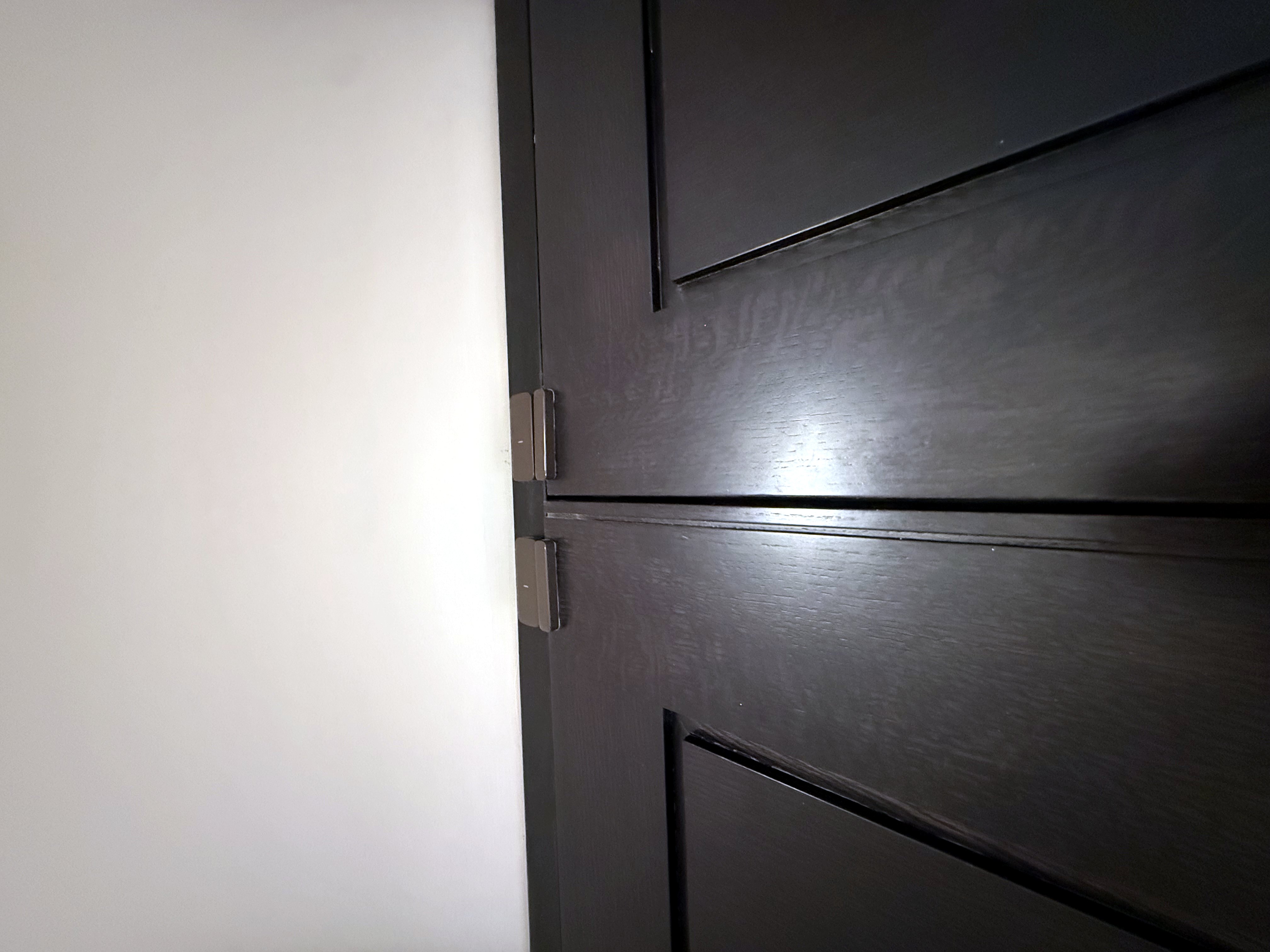 Flush door contact fitted to an internal door frame, aligned so the door closes without fouling the magnet.