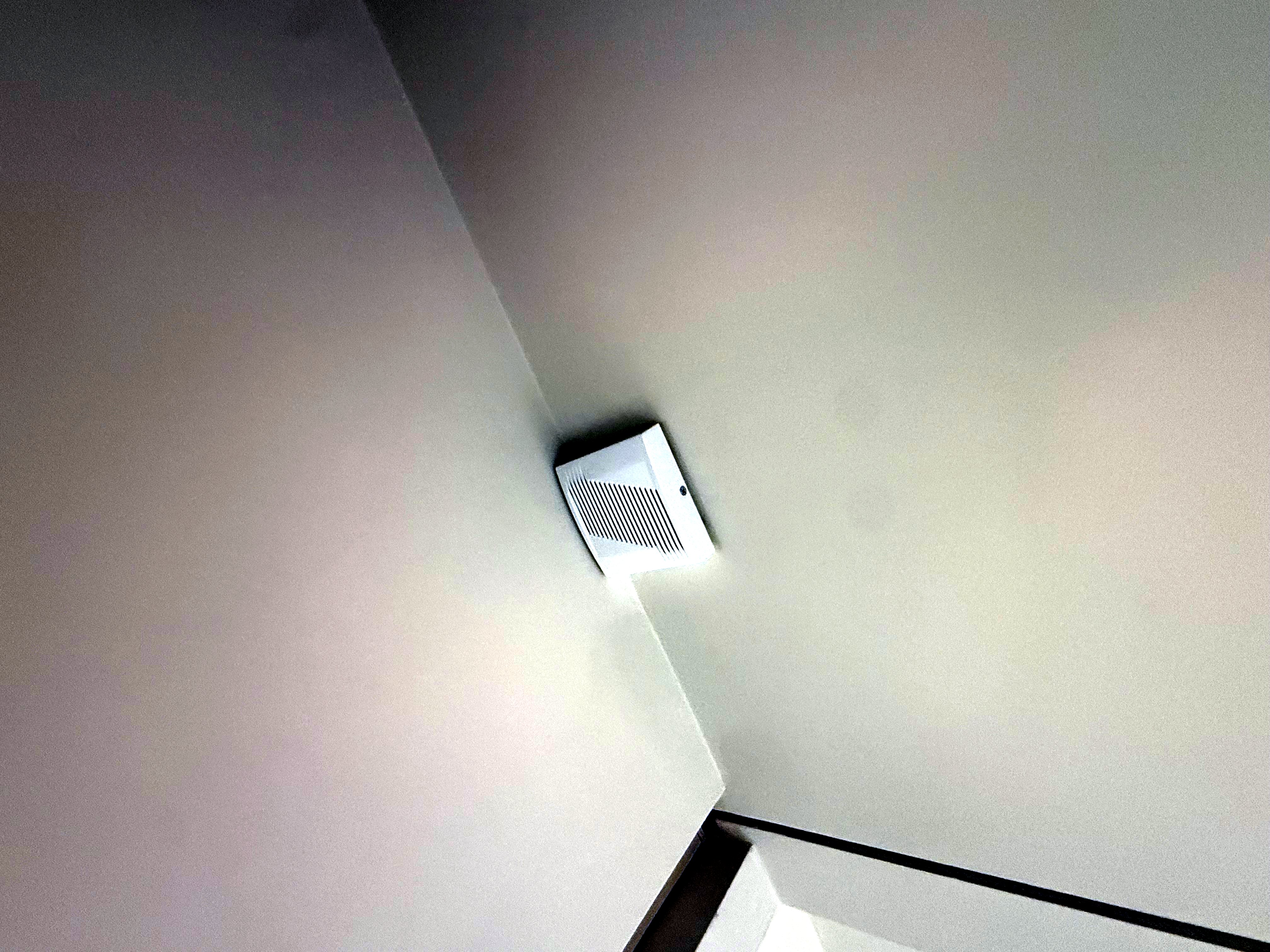 Internal alarm sounder fitted into a ceiling corner